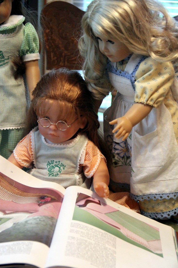 The dolls bake a cake on the "Stitching with Ellie" blog